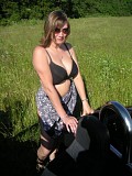 Wild brunette housewife posing in the car and showing her massive bare boobs outdoors