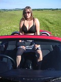 Wild brunette housewife posing in the car and showing her massive bare boobs outdoors