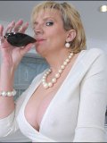 Older blondie with very heavy rack takes a sip of wine and plays with her snatch