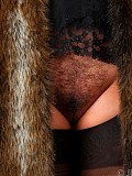 Sexy brunette milf posing in a fur coat and revealing her furry pussy