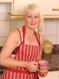 Blond momma with punky hairstyle demonstrates her clit piercing in the kitchen