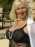 Ravishing slutty mature blonde posing in seductive black lingerie by the pool