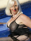 Ravishing slutty mature blonde posing in seductive black lingerie by the pool