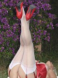 Sandy loves to pose in white stockings and a red corset flaunting her hot body