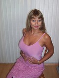 Seductive mature blonde takes her bra off to squeeze and tease her gigantic boobs